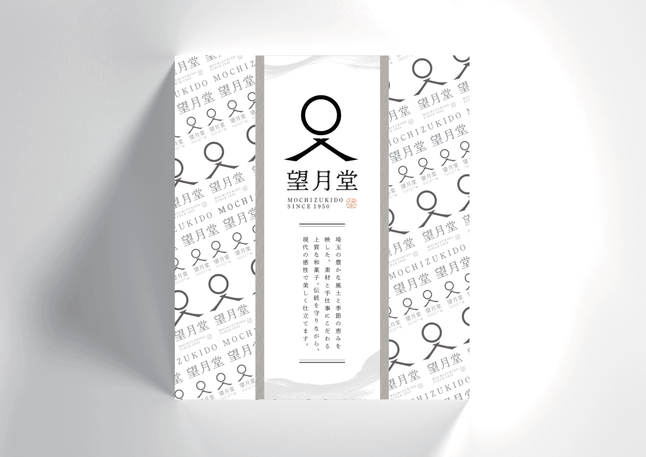 仮想の和菓子ブランド「望月堂」のパッケージデザイン案。ロゴを連続させたパターンの箱に、縦書きのメッセージを入れた帯