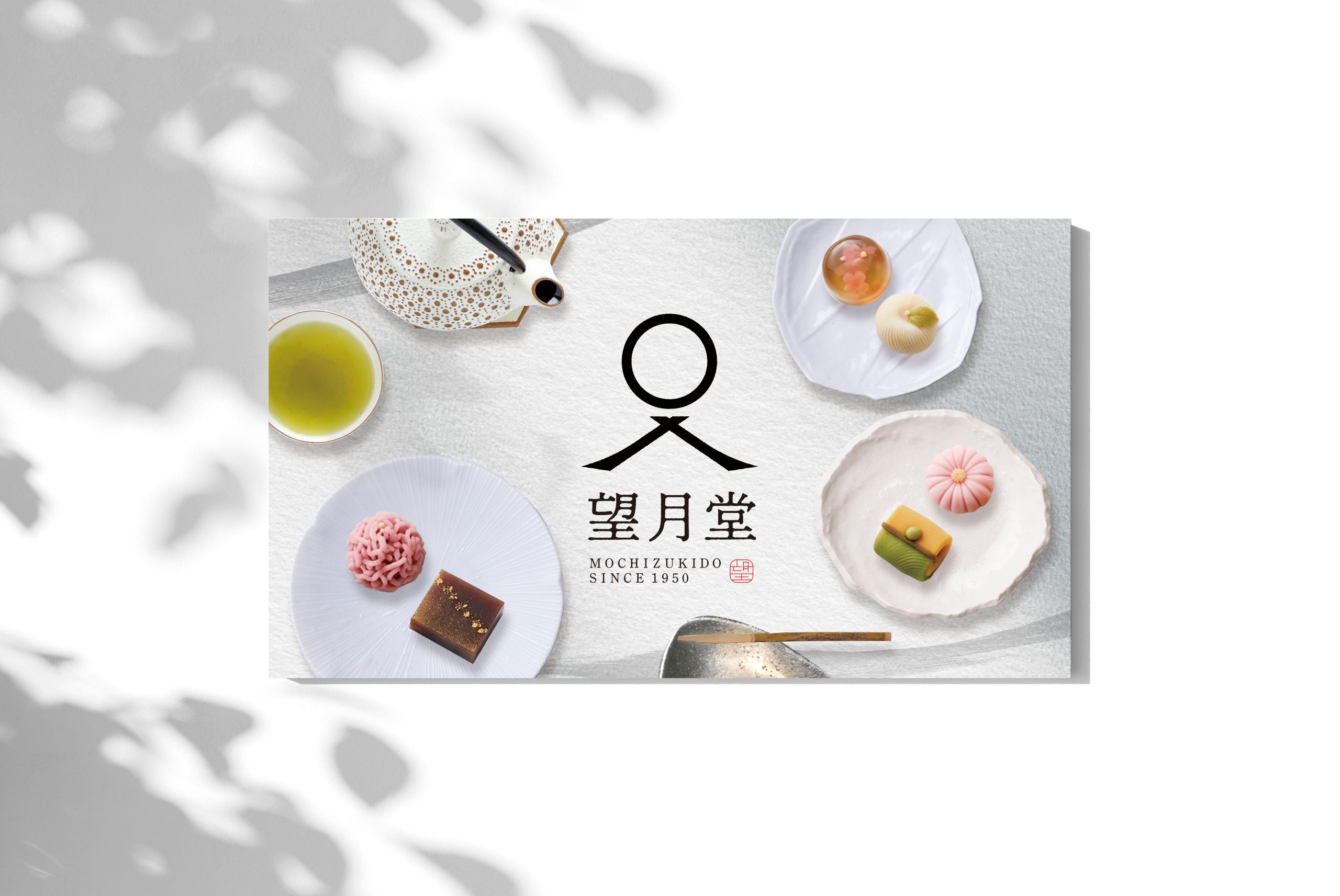 仮想の和菓子ブランド「望月堂」のブランドイメージ。ロゴを中心に、季節の和菓子と煎茶を並べたビジュアル